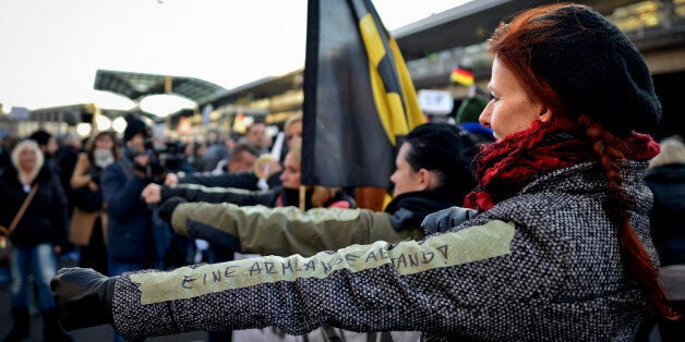 COLOGNE, GERMANY - JANUARY 09: A German far-right supporter demonstrates with a sticker reading 'an arm-length distance' referring to the suggestion of Cologne's mayor for women of how to behave to prevent being assaulted by men at Cologne's train station on January 9, 2016 in Cologne, Germany. Over 100 women have filed charges of sexual molestation, robbery and in two cases, rape, stemming from aggressive groping and other behavior by gangs of drunken men described as Arab or North African at Hauptbahnhof on New Year's Eve. Police have recently stated that at least some of the men identified so far are refugees, which is feeding the propaganda of right-wing groups opposed to Germany's open-door refugee policy. Germany took in approximately 1.1 million migrants and refugees in 2015. (Photo by Sascha Schuermann/Getty Images)