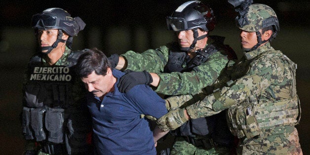 Mexican army soldiers escort drug lord Joaquin "El Chapo" Guzman to a helicopter to be transported to a maximum security pris