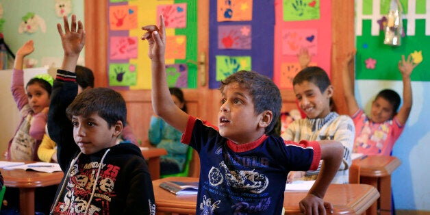 Syrian refugee students participate in a lesson during the visit of the European Commissioner for Humanitarian Aid and Crisis Management Christos Stylianides, to their school in Taanayel, in the eastern Bekaa valley, Lebanon, Tuesday, Nov. 3, 2015. The European Commission will give 62 million Euro in humanitarian aid to support Syrians displaced by the conflict inside the war-torn country. (AP Photo/Hassan Ammar)