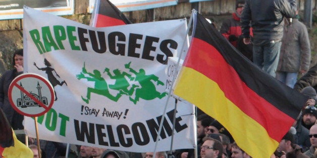 Right-wing demonstrators hold a sign "Rapefugees not welcome - !Stay away!" and a sign with a crossed out mosque as they march in Cologne, Germany Saturday Jan. 9, 2016. Womenâs rights activists, far-right demonstrators and left-wing counter-protesters all took to the streets of Cologne on Saturday in the aftermath of a string of New Yearâs Eve sexual assaults and robberies in Cologne blamed largely on foreigners. (AP Photo/Juergen Schwarz)