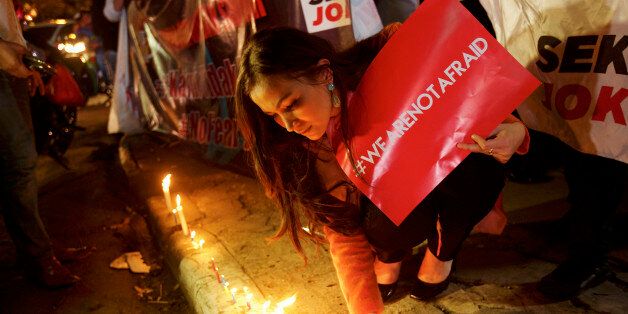 JAKARTA, INDONESIA - JANUARY 15: An Indonesian woman lights candles near the site of yesterday's terrorist attack during a 'We Are Not Afraid' rally on January 15, 2016 in Jakarta, Indonesia. Islamic State suicide bombers and gunmen struck the capital of Indonesia on January 14, killing at least two and wounding 24 during the attacks. (Photo by Ed Wray/Getty Images)