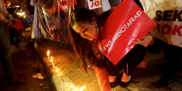 JAKARTA, INDONESIA - JANUARY 15: An Indonesian woman lights candles near the site of yesterday's terrorist attack during a '
