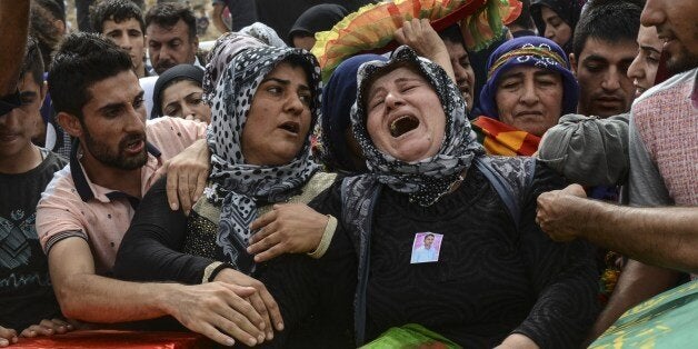 Relatives and mourners gather around the coffins of people killed during clashes between Turkish forces and militants of the