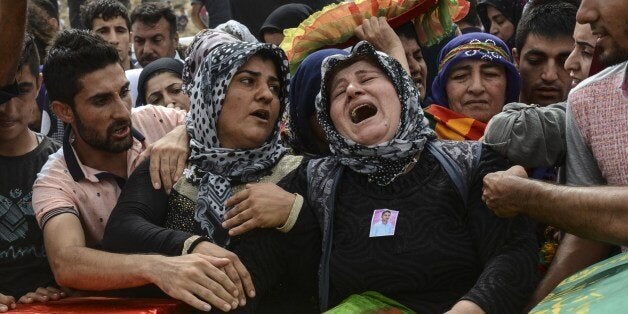 Relatives and mourners gather around the coffins of people killed during clashes between Turkish forces and militants of the Kurdistan Workers' Party (PKK) in the Kurdish-majority city of Cizre, in southeastern Turkey, on September 13, 2015, following a week-long curfew imposed to support a Turkish military operation against the Kurdish rebels. The pro-Kurdish Peoples' Democratic Party (HDP) has said over 20 civilians were killed during the operation, which deprived residents of access to essential amenities and triggered food shortages. Clashes between the state and PKK, which resumed in late July, have upended a 2013 ceasefire that had sparked hopes of an end to the PKK's three-decade insurgency, which has killed tens of thousands of people. AFP PHOTO/ILYAS AKENGIN (Photo credit should read ILYAS AKENGIN/AFP/Getty Images)