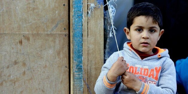 LEBANON, BEIRUT - DECEMBER 31: A Syrian child one of those who have been forced to leave their homes because of the war in their country since 2011, stands outside a makeshift tent at the Al Hayat and Al Nour refugee camp in Cabal Lebanon region, Lebanon on December 31, 2015. As the weather cools down, Syrian refugees struggle to survive heavy winter conditions at the tent city. (Photo by Ratib Al Safadi/Anadolu Agency/Getty Images)