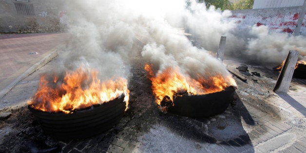 Tire fires burn in a third straight day of protests against Saudi Arabia's execution of Saudi Shiite cleric Sheikh Nimr al-Nimr in the western Shiite village of Karzakan, Bahrain, Monday, Jan. 4, 2016. Allies of Saudi Arabia, including neighboring Bahrain, followed the kingdom's lead on Monday and began scaling down their diplomatic ties to Iran in the wake of the ransacking of Saudi diplomatic missions in Iran after al-Nimr's execution. (AP Photo/Hasan Jamali)