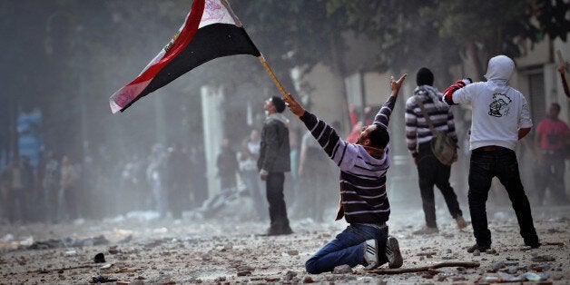 [UNVERIFIED CONTENT] CAIRO, EGYPT - DECEMBER 16: An Egyptian protester on his knees during clashing with army soldiers inside the Cabinet Ministry headquarters that overlooks the Qasr Ainy street, off Tahrir Square. The military soldiers where throwing rocks and marble pieces from the rooftop of the building. On December 16, 2011 military police abducted a protester 'Abboudy' from the cabinet sit-in in Qasr Ainy street near Tahrir square. Abboudy was badly beaten and tortured by military forces. Hours later clashes erupted between protesters and military forces leading to a non-stop battle that lasted for more than 48 hours.More than ten were killed in the clashes. (Photo by: Jonathan Rashad)