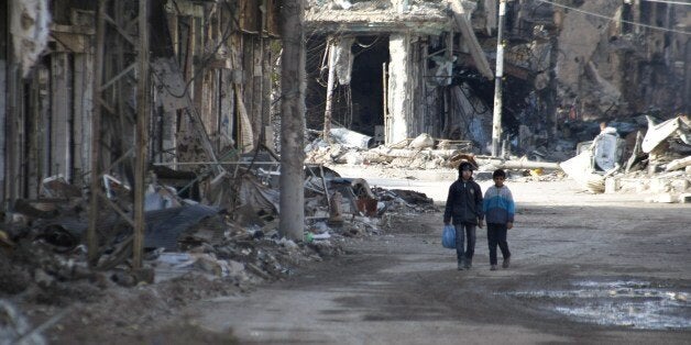 Syrian children walk through a street as they bring food back to their families in the northeastern city of Deir Ezzor on January 23, 2014. Nearly 1,400 people have been killed in Syria since clashes between rebel forces and the jihadist Islamic State of Iraq and the Levant erupted this month, a monitor said. AFP PHOTO/AHMAD ABOUD (Photo credit should read AHMAD ABOUD/AFP/Getty Images)