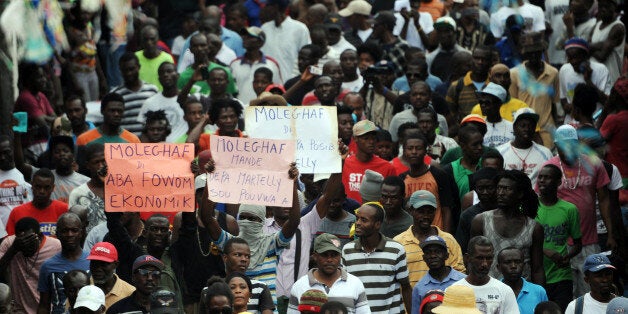 Protesters march in Port-au-Prince on January 24, 2016 to demand the resignation of Haitian President, Michel Martelly. Haiti's electoral authority postponed Sunday's planned presidential run-off amid mounting opposition street protests and voting fraud allegations. The second round of presidential elections was scheduled for January 24 between ruling party candidate Jovenel Moise and Jude Celestin but was suspended by CEP. Haiti now awaits a new calendar for the second round of presidential elections and legislatives elections. / AFP / HECTOR RETAMAL (Photo credit should read HECTOR RETAMAL/AFP/Getty Images)