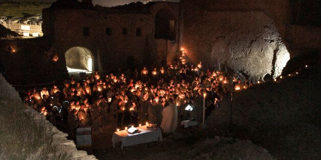 In this April 3, 2010, photo released by the U.S. Army, soldiers celebrate a Catholic Easter mass at St. Elijah's Monastery on the outskirts of Mosul, Iraq. Before it was razed, the partially restored, 27,000-square-foot stone and mortar building stood fortress-like on a hill above Mosul. Although the roof was largely missing, it had 26 distinctive rooms including a sanctuary and chapel. Satellite photos taken after its destruction show âthat the stone walls have been literally pulverized,â said imagery analyst Stephen Wood, CEO of Allsource Analysis, who pinpointed the destruction between August and September 2014. (Staff Sgt. Russell Lee Klika/U.S. Army via AP)