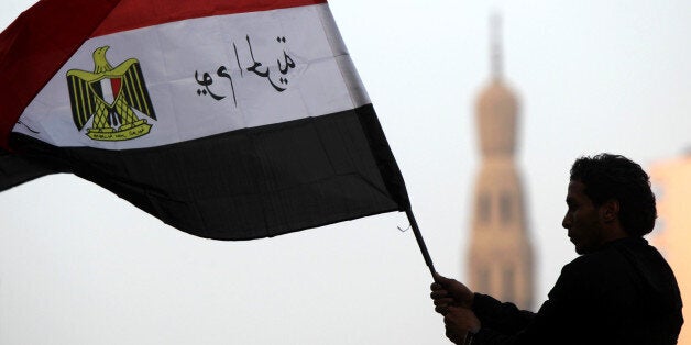 An Egyptian youth waves the national flag with slogan in Arabic that reads. '25th of January, Day of the Freedom' following morning prays, celebrating the start of the three-day feast known in Arabic Eid al-Fitr, which marks the end of the holy fasting month of Ramadan, in Tahrir Square, the scene of mass demonstration which brought down the regime of former president Hosni Mubarak, in Cairo, on August 30, 2011. AFP PHOTO / KHALED DESOUKI (Photo credit should read KHALED DESOUKI/AFP/Getty Images)