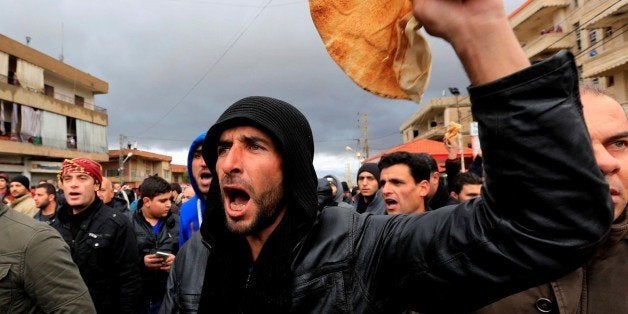 BEQAA, LEBANON - JANUARY 8: Demonstrators holding breads chant slogans against Syrian regime and Hezbollah, during a protest remarking the humanitarian crisis in Syria's Madana town, on January 8, 2016 in Beqaa, Lebanon. (Photo by Ratib Al Safadi/Anadolu Agency/Getty Images)