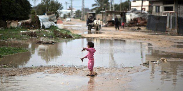 A Palestinian girl walks in flooded water following a winter storm in the village of Al-Moghraga near the Nuseirat refugee camp in the central Gaza Strip on February 22, 2016. / AFP / MAHMUD HAMS (Photo credit should read MAHMUD HAMS/AFP/Getty Images)