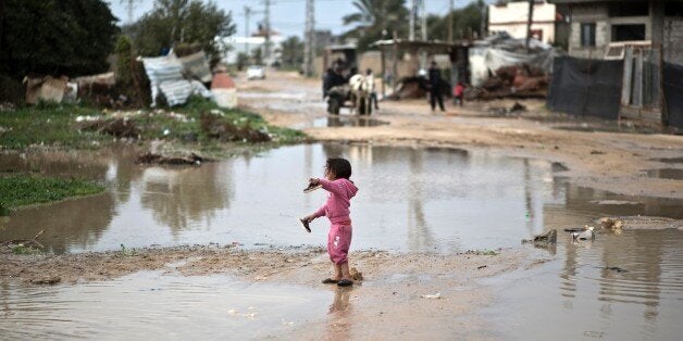 A Palestinian girl walks in flooded water following a winter storm in the village of Al-Moghraga near the Nuseirat refugee ca
