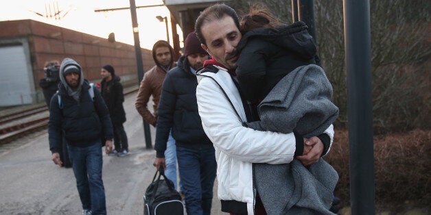 PADBORG, DENMARK - JANUARY 06: Migrants, many of them from Syria, walk to police vans after police found them while checking