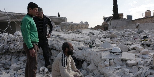 ALEPPO, SYRIA - FEBRUARY 2: Civil defense team members try to clear the debris of a building to rescue the people buried under the wreckage after the war crafts belonging to the Russian army carried out airstrikes on the residential areas in the opposition controlled Anadan district of Aleppo, Syria on February 2, 2016. (Photo by Beha El-Halebi/Anadolu Agency/Getty Images)