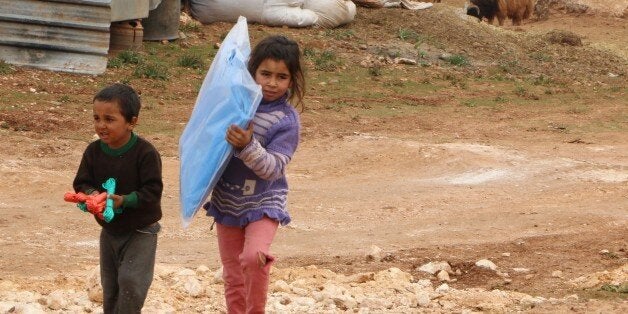 ALEPPO, SYRIA - JANUARY 31: Turkmen children carry wait for food distribution at al-Ra'ee camp, southern Aleppo in Syria on January 31, 2016. Turkmen who fled their homes following attacks by Syrian and Russian forces, live under harsh conditions at al-Ra'ee camp. (Photo by Mustafa Sultan/Anadolu Agency/Getty Images)