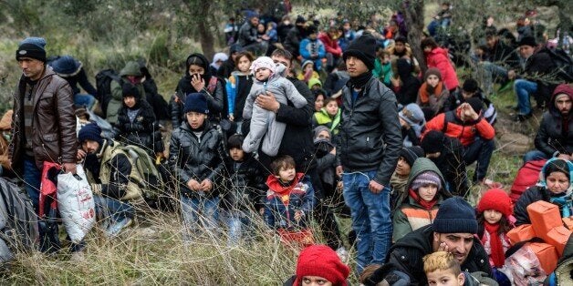 Migrants wait with life vests while they are camping after being cheated by smugglers on January 29, 2016 in Kucukkuyu distri