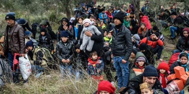 Migrants wait with life vests while they are camping after being cheated by smugglers on January 29, 2016 in Kucukkuyu district in Canakkale, as they try to reach the Greek island of Lesbos. The migrants reported that the smuglers who proposed their services to help them cross the sea to the Greek island of Lesbos lied about the boat's size. They refused to get on the small sized boat they discovered on the boarding spot chosen by smuglers. / AFP / OZAN KOSE (Photo credit should read OZAN KOSE/AFP/Getty Images)