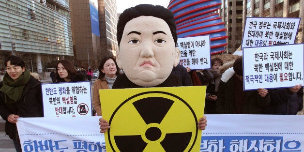 A South Korean university student wearing a mask depicting North Korean leader Kim Jong Un participates in a rally against North Korea's announcement that it had tested a hydrogen bomb in Seoul, South Korea, Thursday, Jan. 7, 2016. North Korea's declaration that it had tested a hydrogen bomb for the first time was greeted with widespread condemnation - but also skepticism - as world powers vowed Wednesday to punish the impoverished and defiant nation with new international sanctions. The banners read " We denounce North Korea' nuclear test." (AP Photo/Ahn Young-joon)