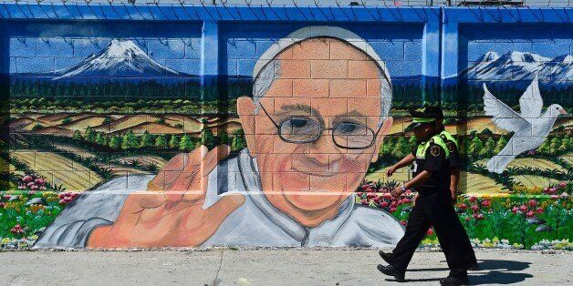 Two policemen walk past a poster welcoming Pope Francis to Ecatepec, on the north east side of Mexico City, on February 5, 2016. The Pope will visit Mexico February 12-17. AFP PHOTO/RONALDO SCHEMIDT / AFP / RONALDO SCHEMIDT (Photo credit should read RONALDO SCHEMIDT/AFP/Getty Images)