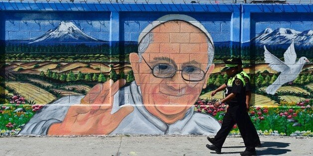 Two policemen walk past a poster welcoming Pope Francis to Ecatepec, on the north east side of Mexico City, on February 5, 2016. The Pope will visit Mexico February 12-17. AFP PHOTO/RONALDO SCHEMIDT / AFP / RONALDO SCHEMIDT (Photo credit should read RONALDO SCHEMIDT/AFP/Getty Images)