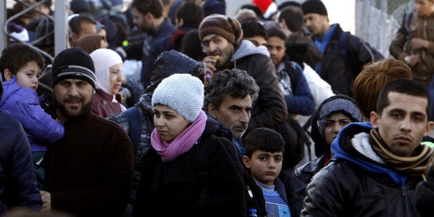 Refugees gather upon their arrival at the transit center for refugees near northern Macedonian village of Tabanovce, before c