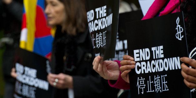 LONDON, ENGLAND - OCTOBER 20: A supporter of Amnesty International holds a sign with the slogan 'end the crackdown' in protest against claims of a deterioration in human rights and censorship of the internet and media during a state visit by Chinese President Xi Jinping on October 20, 2015 in London, England. The President of the People's Republic of China, Mr Xi Jinping and his wife, Madame Peng Liyuan, are paying a State Visit to the United Kingdom as guests of The Queen. They will stay at Buckingham Palace and undertake engagements in London and Manchester. The last state visit paid by a Chinese President to the UK was Hu Jintao in 2005. (Photo by Ben Pruchnie/Getty Images)