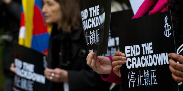 LONDON, ENGLAND - OCTOBER 20: A supporter of Amnesty International holds a sign with the slogan 'end the crackdown' in protest against claims of a deterioration in human rights and censorship of the internet and media during a state visit by Chinese President Xi Jinping on October 20, 2015 in London, England. The President of the People's Republic of China, Mr Xi Jinping and his wife, Madame Peng Liyuan, are paying a State Visit to the United Kingdom as guests of The Queen. They will stay at Buckingham Palace and undertake engagements in London and Manchester. The last state visit paid by a Chinese President to the UK was Hu Jintao in 2005. (Photo by Ben Pruchnie/Getty Images)