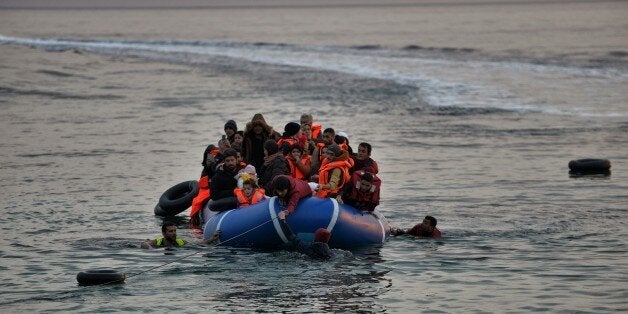 Refugees and migrants massed onto an inflatable boat reach Mytilene, northern island of Lesbos, after crossing the Aegean sea