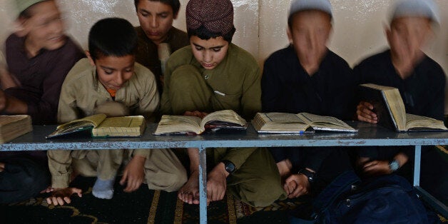 Afghan boys learn and memorize Koran at a Madrassa during the month of Ramadan in Kabul on July 15, 2013. Throughout the month, devout Muslims must abstain from food and drink from dawn until sunset when they break the fast with the Iftar meal. AFP PHOTO/ Massoud HOSSAINI (Photo credit should read MASSOUD HOSSAINI/AFP/Getty Images)