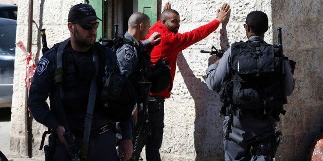 Israeli policemen body-check a Palestinian youth at Damascus Gate in the Old City of Jerusalem on February 17, 2016. / AFP / AHMAD GHARABLI (Photo credit should read AHMAD GHARABLI/AFP/Getty Images)