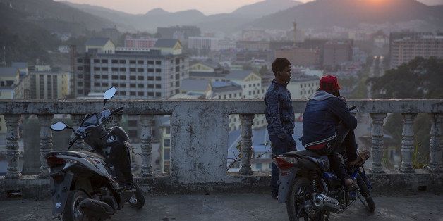 MONG LA, MYANMAR - FEBRUARY 16: Young men chat at a pagoda overlooking the city on February 16, 2016 in Mong La, Myanmar. Mong La, the capital of Myanmar's Special Region No. 4, is a mostly lawless area where Chinese tourists are able to cross the border for exotic poached animals, gambling, and prostitution. (Photo by Taylor Weidman/Getty Images)