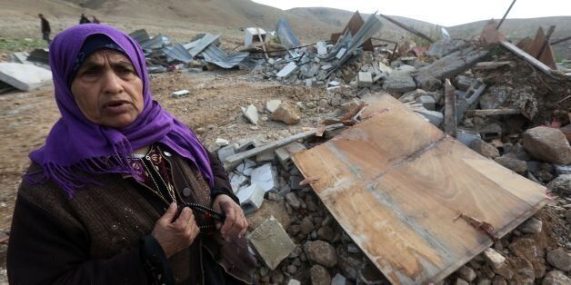 An elderly Palestinian woman stands near the rubble of her house after it was demolished by Israeli authorities on February 10, 2016 in the West Bank village of Jeftlek, in the Jordan valley near Jericho.Israel often demolishes buildings constructed without the required Israeli permits in Area C of the West Bank, which is under full Israeli control. / AFP / JAAFAR ASHTIYEH (Photo credit should read JAAFAR ASHTIYEH/AFP/Getty Images)