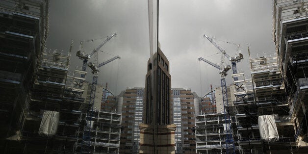 Construction cranes are reflected in the window of a neighboring building of the London Wall Place commercial property construction site, in the City of London, U.K., on Thursday, Feb. 25, 2016. The U.K. currency has tumbled this year amid concern that Britain will vote to leave the European Union, hampering trading and discouraging foreign investment. Photographer: Luke MacGregor/Bloomberg via Getty Images