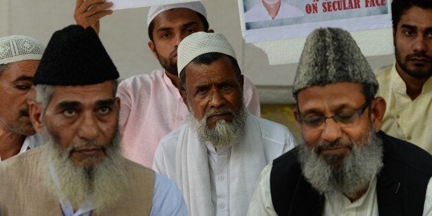 Indian Muslim political activists sit during a protest in New Delhi on October 7, 2015, held to call for an investigation int
