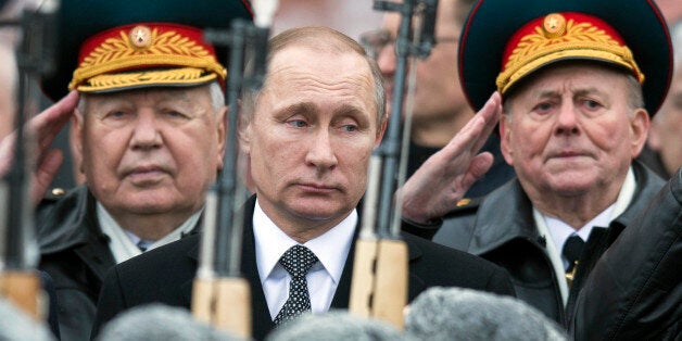 Russian President Vladimir Putin, center, attend a wreath-laying ceremony at the Tomb of the Unknown Soldier in Moscow, Russia, Tuesday, Feb. 23, 2016. The Defenders of the Fatherland Day, celebrated in Russia on Feb. 23, honors the nation's military and is a nationwide holiday. (AP Photo/Pavel Golovkin)