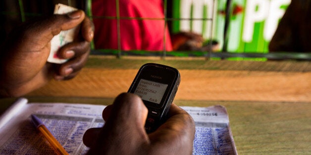 An employee uses a Nokia 1200 mobile phone inside an M-Pesa store in Nairobi, Kenya, on Sunday, April 14, 2013. In the six years since Kenya's M-Pesa brought banking-by-phone to Africa, the service has grown from a novelty to a bona fide payment network. Photographer: Trevor Snapp/Bloomberg via Getty Images