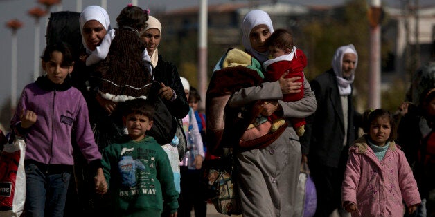 Women and children walk from the rebel held suburb of Moadamiyeh to the government held territory Tuesday Oct. 29, 2013 in Damascus, Syria. Nearly 2,000 residents of the besieged western Damascus suburb of Moadamiyeh have fled their homes and have surrendered to the Syrian authorities after reports of starvation and disease triggered an international outcry for their help. (AP Photo/Dusan Vranic)