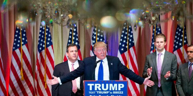 Republican presidential candidate Donald Trump, accompanied by New Jersey Gov. Chris Christie, left, and his son, Eric Trump, third from left, speaks during a news conference on Super Tuesday primary election night in the White and Gold Ballroom at The Mar-A-Lago Club in Palm Beach, Fla., Tuesday, March 1, 2016. (AP Photo/Andrew Harnik)