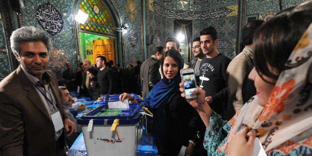 TEHRAN, IRAN - FEBRUARY 26: Iranian women take a mobile phone portrait while they vote in key elections for Parliament and th