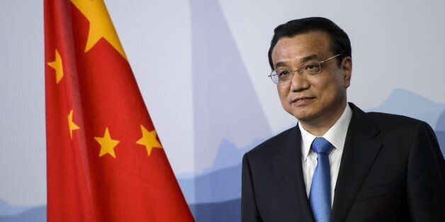 Chinese Prime Minister Li Keqiang stands next to the national flag after an official meeting on May 24, 2013 at the Lohn residency in Kehrsatz near Bern. Li was poised to sign a key accord with Switzerland bringing closer a free-trade deal seen as a touchstone for Beijing's growing global ties. He arrived in Switzerland on the first stop of his debut visit to Europe since taking over in March in Beijing's once-in-a-decade power transfer. AFP PHOTO / FABRICE COFFRINI (Photo credit should read FABRICE COFFRINI/AFP/Getty Images)