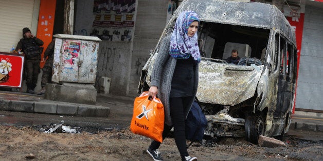 DIYARBAKIR, TURKEY - MARCH 15: A woman walks through the streets after fighting between members of the PKK and the police on