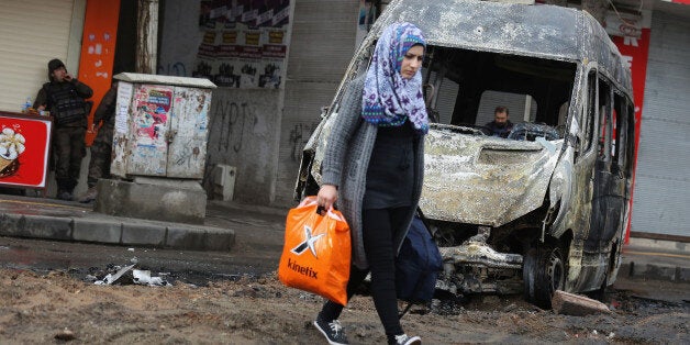 DIYARBAKIR, TURKEY - MARCH 15: A woman walks through the streets after fighting between members of the PKK and the police on March 15, 2016 in Diyarbakir, Turkey. Heavy fighting between members of Kurdistan Workers Party (PKK) and Police forces have left at least three people dead and several injured. President Recep Tayyip Erdogan vowed a crackdown on the PKK following Sunday's suicide bomb attack in Ankara, which has been widely blamed on the Kurdish separatist group. (Photo by Awakening/Getty Images)