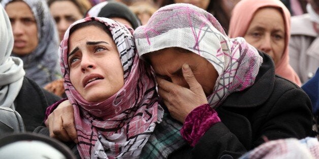 TOPSHOT - The sister (L) of Mohammed Ismael, who died in one of three suicide car bombings claimed by the Islamic State (IS) group in the nearby town of Tal Tamr earlier this week, mourns during his funeral in Qamishli, a Kurdish-majority city in Syria's northeastern Hasakeh province, on December 13, 2015. Tal Tamr, in the Khabur region, is controlled by Kurdish forces and has been targeted in the past by IS jihadists, who in February overran much of Khabur and kidnapped at least 220 Assyrian Christians. AFP PHOTO / DELIL SOULEIMAN / AFP / DELIL SOULEIMAN (Photo credit should read DELIL SOULEIMAN/AFP/Getty Images)