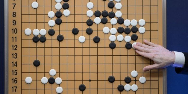 A commentator in a media room positions pieces forming a replica of a game between 'Go' player Lee Se-Dol and a Google-developed super-computer, in Seoul on March 13, 2016.A South Korean Go grandmaster scored his first win over a Google-developed supercomputer, in a surprise victory after three humiliating defeats in a high-profile showdown between man and machine. Lee Se-Dol thrashed AlphaGo after a nail-biting match that lasted for nearly five hours -- the fourth of the best-of-five series in which the computer clinched a 3-0 victory on March 12. / AFP / Ed Jones (Photo credit should read ED JONES/AFP/Getty Images)