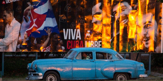 A taxi driving a classic American car passes a billboard that reads in Spanish: "Long live free Cuba" in Havana, Cuba, Monday