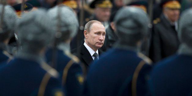 Russian President Vladimir Putin passes an honor guard formation during wreath-laying ceremony at the Tomb of the Unknown Soldier in Moscow, Tuesday, Feb. 23, 2016. The Defenders of the Fatherland Day, celebrated in Russia on Feb. 23, honors the nation's military and is a nationwide holiday. (AP Photo/Pavel Golovkin)