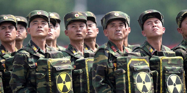 FILE - In this July 27, 2013, file photo, North Korean soldiers turn and look towards their leader Kim Jong Un as they carry