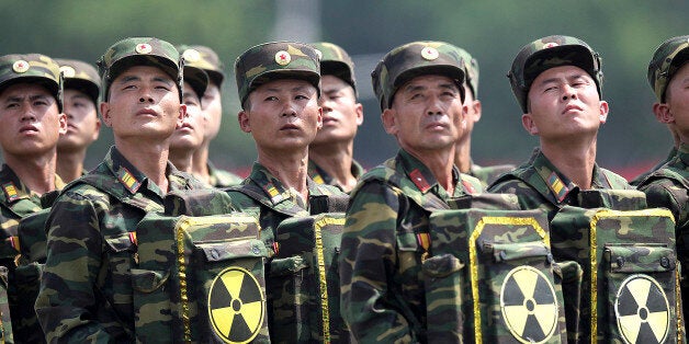 FILE - In this July 27, 2013, file photo, North Korean soldiers turn and look towards their leader Kim Jong Un as they carry packs marked with the nuclear symbol as they parade during a ceremony marking the 60th anniversary of the Korean War armistice in Pyongyang, North Korea. North Korea claims to have tested its first H-bomb on Jan. 6, the day after the Department of Defense report came out. That claim has been disputed, but there is no doubt it has some nuclear weaponsâ capability and its technicians are hard at work improving the nuclear weapons in quantity and quality. (AP Photo/Wong Maye-E, File)